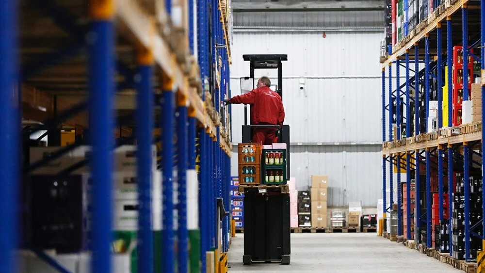 Lagerfachkraft der Wein Compagny befüllt auf Gabelstapler die Lagerregale